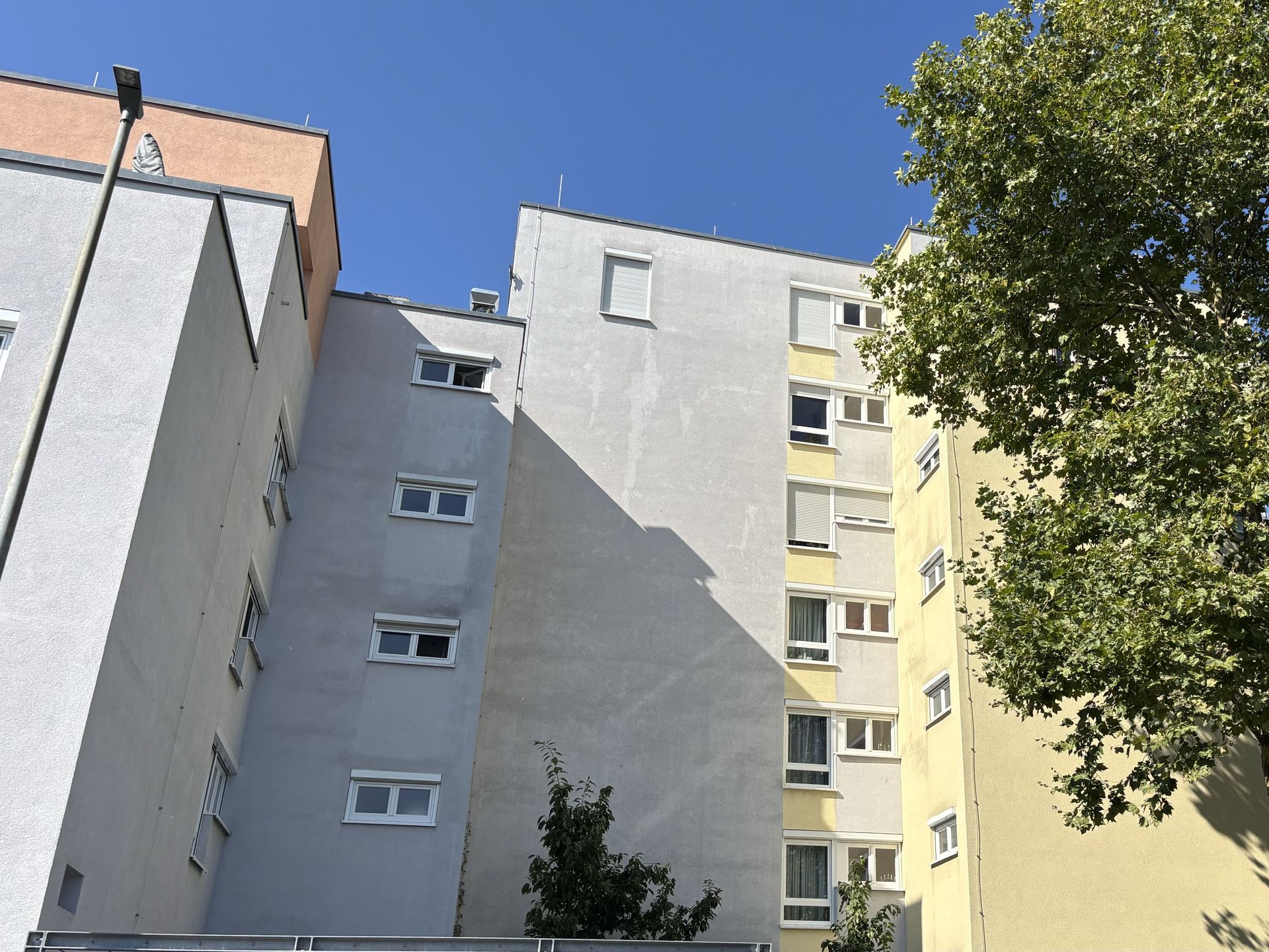 Das Bild zeigt ein Mehrfamilienhaus mit heller Fassade.