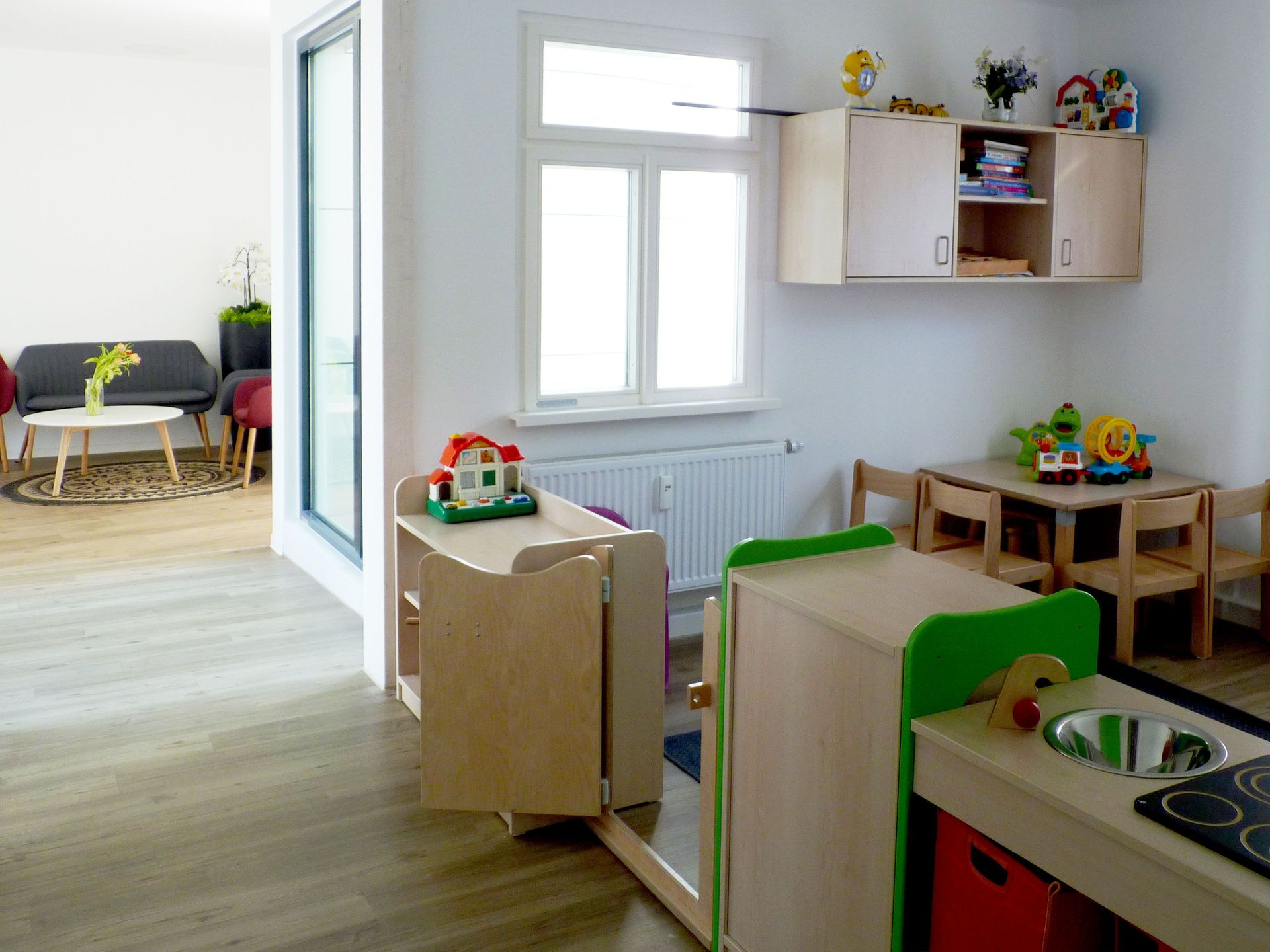 Das Bild zeigt eine Innenaufnahme des Gebäudes. Man sieht eine Spielfläche für Kinder mit Spielzeugen.