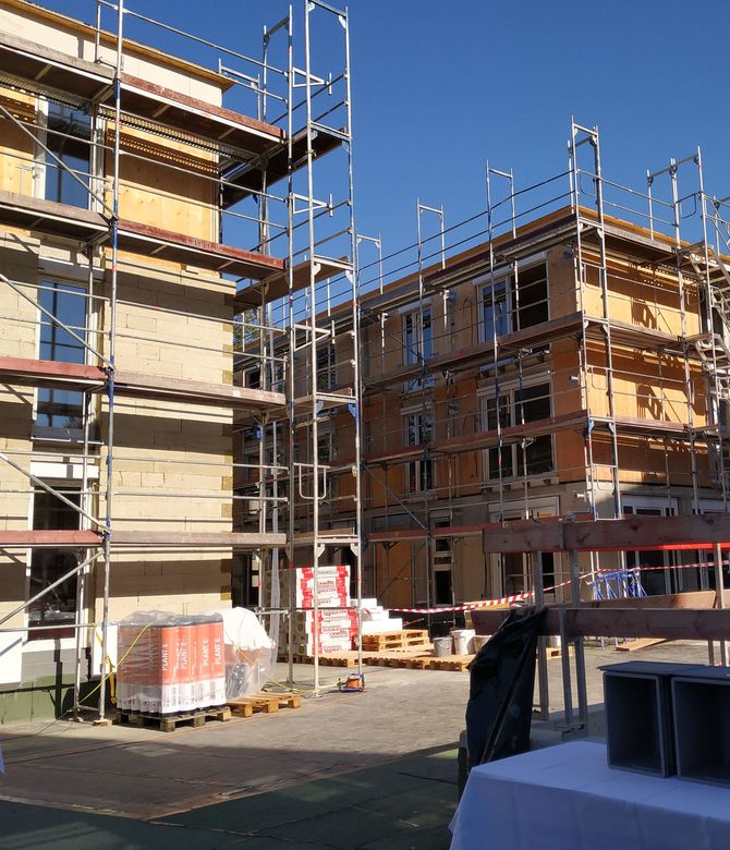 Das Bild zeigt zwei Häuser mit Baugerüsten. Link zum Bereich Neubau Mietwohnungen.