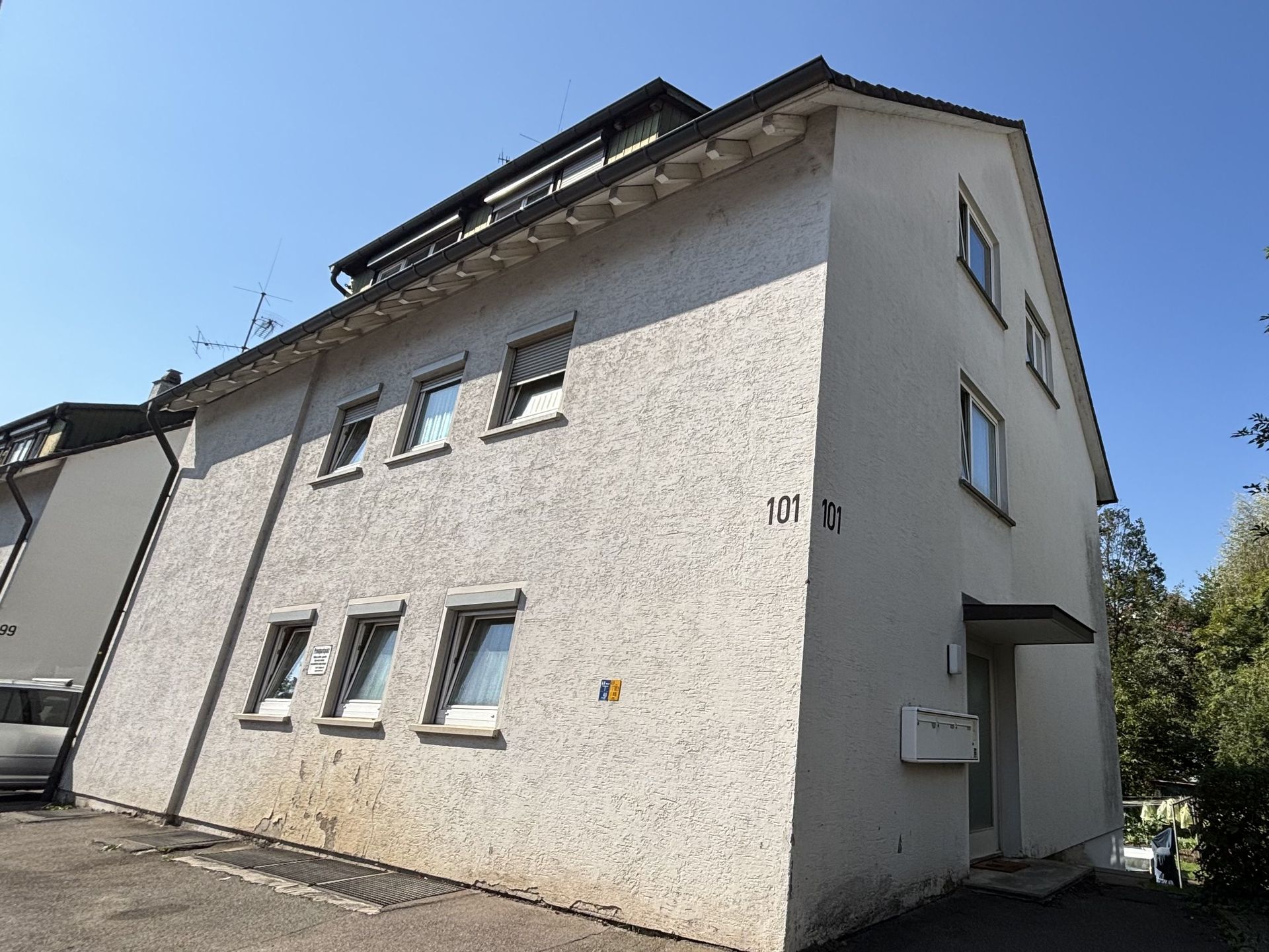Das Bild zeigt ein mehrstöckiges Mehrfamilienhaus mit heller Fassade.