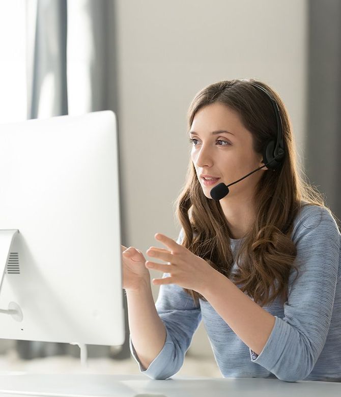 Das Bild zeigt eine Frau mit Headset am Computer. Link zum Bereich Service.